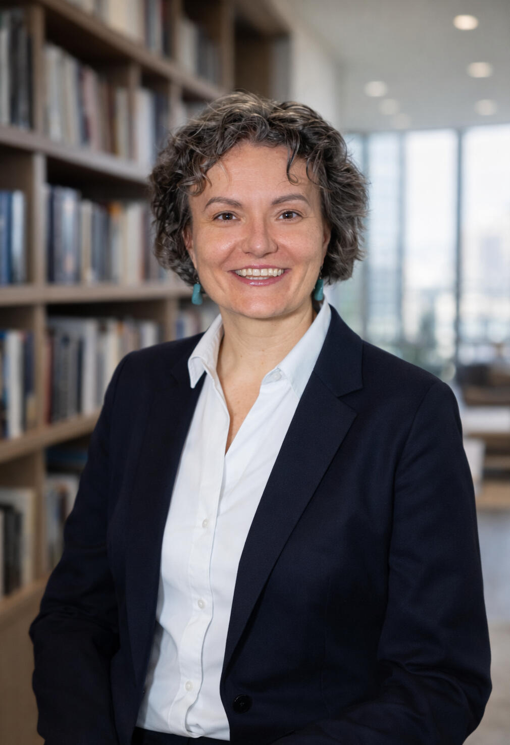 The image depicts mediator Mariya, standing in the office hallway wearing a suit. She is smiling, looking into the camera